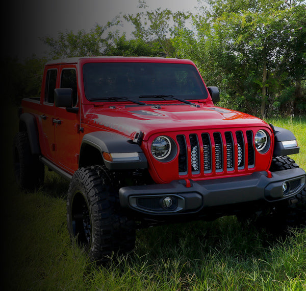 Red Jeep JT Gladiator in a grassy outdoor setting