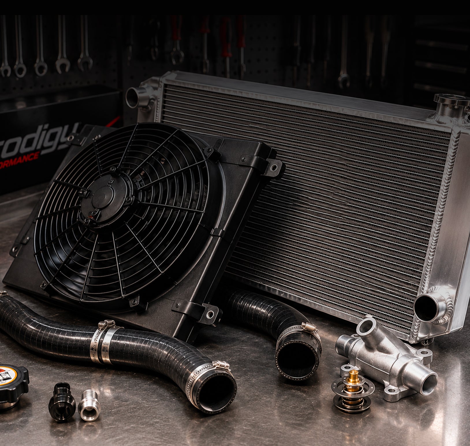 Radiator with fan and hoses on a metal surface with tools in the background
